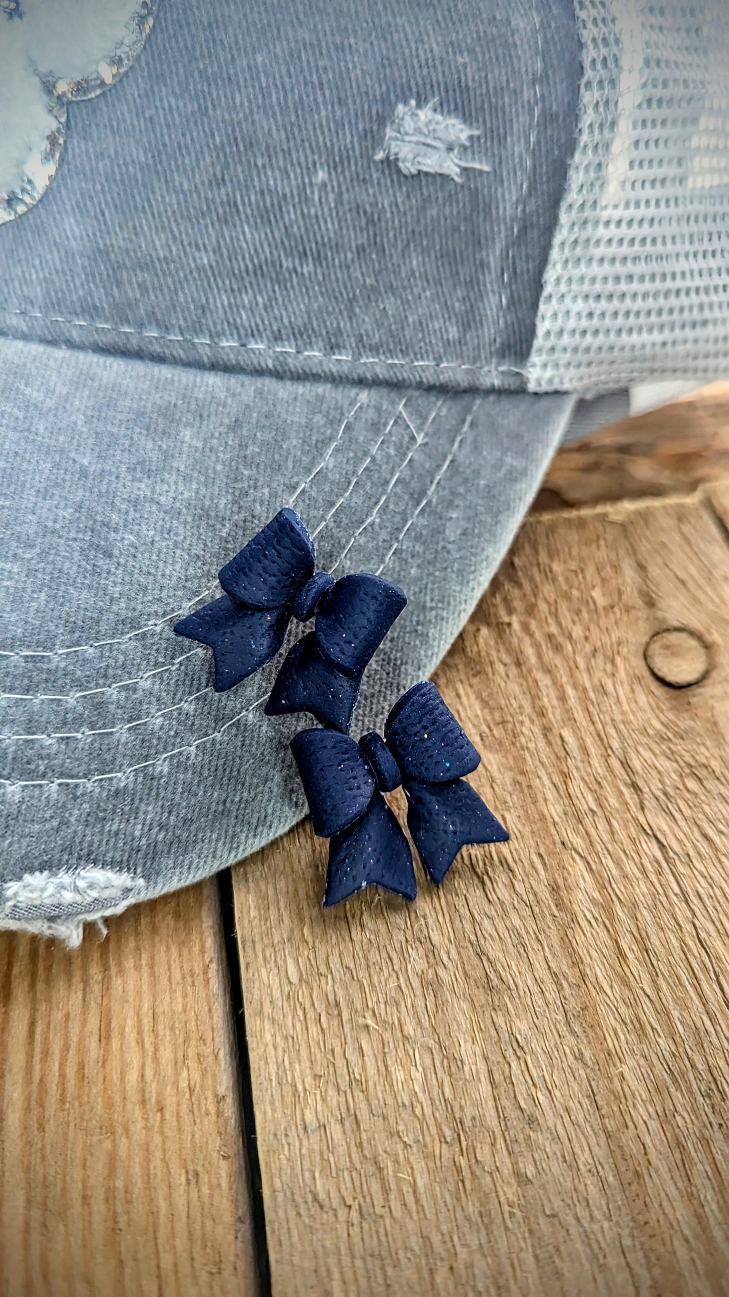 Set: Grey distressed mesh back pawprint hat and navy bow stud earrings