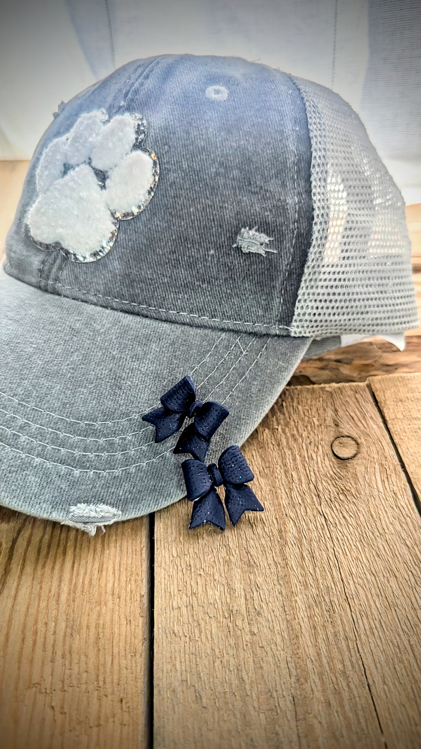 Set: Grey distressed mesh back pawprint hat and navy bow stud earrings